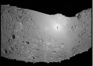 An image of the Itokawa asteroid captured by the Hayabusa probe. The probes shadow is seen on the asteroid.