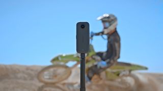 Akaso 360 action camera with dirt bike behind it