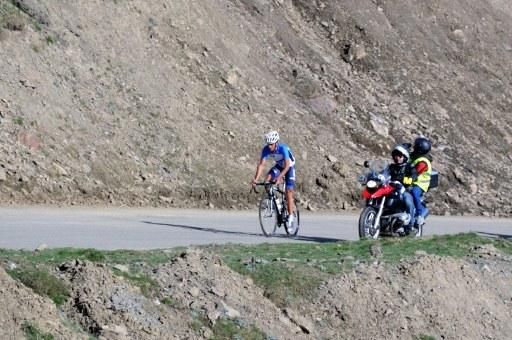 Alberto Contador is chased up the climb by a film crew