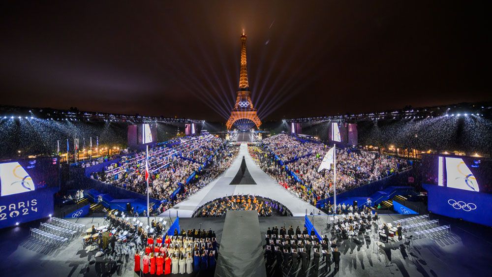 Olympic Games - the Eiffel Tower at night with rings and crowd