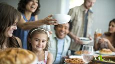 A family gathering for a meal. Adults and children around a table.