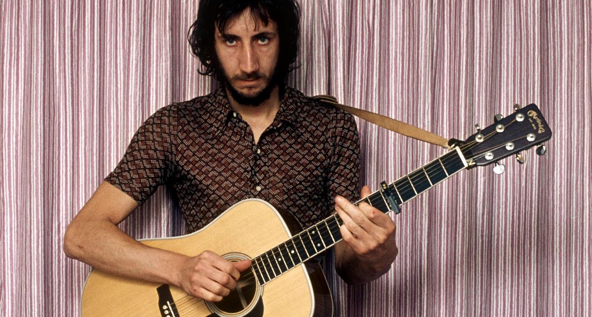 A portrait of a long-haired Pete Townshend playing a Martin dreadnought capoed at the 5th fret, with striped curtains in the background.