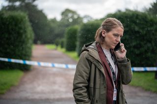 Gemma Whelan on the phone with police tape behind her.
