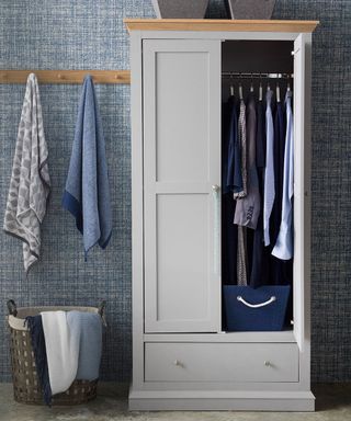 wooden wardrobe with clothes and wooden wall hanger fitted on wall