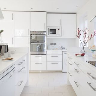 White kitchen with white cabinets and white floor tiles