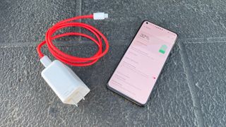 A OnePlus 9 next to its charger