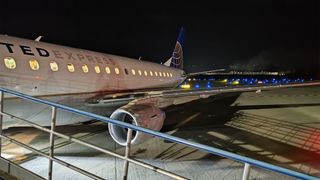 A photo of a United Express airplane at night