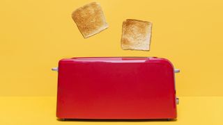 Two slices of toast popping out of a toaster.
