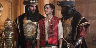 Mena Massoud surrounded by guards in Aladdin