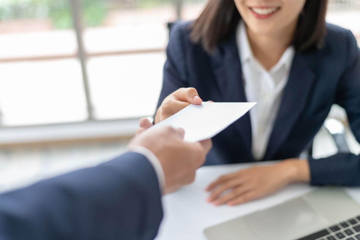 Comms offering, man giving woman a paper