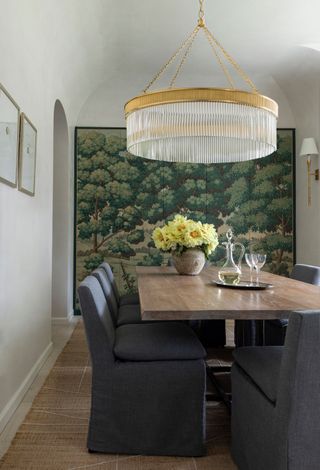 a dining room with storage covered in a woodland wallpaper mural