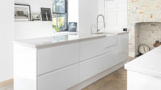 white gloss kitchen with narrow kitchen island to suggest small kitchen storage ideas