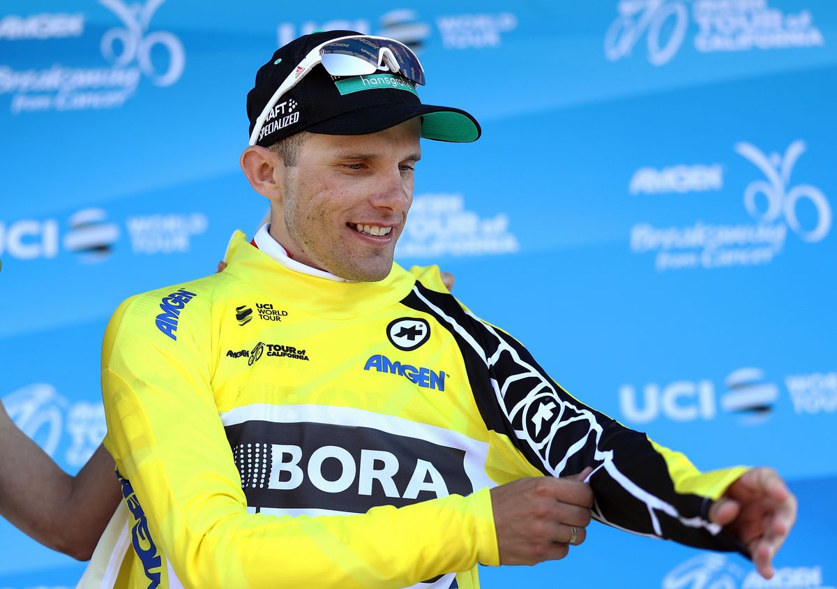 Rafal Majka (Bora-Hansgrohe) pulls on the leader's yellow jersey