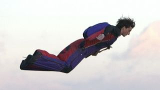 Dean Potter flying through the air in red and blue wingsuit in HBO's The Dark Wizard