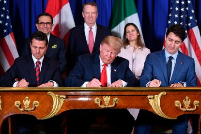 Mexico's President Enrique Pena Nieto (L) US President Donald Trump (C) and Canadian Prime Minister Justin Trudeau, sign a new free trade agreement in Buenos Aires, on November 30, 2018