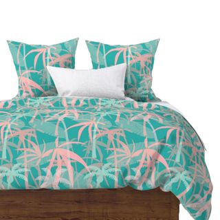 A turquoise and pastel pink palm tree printed bedding set