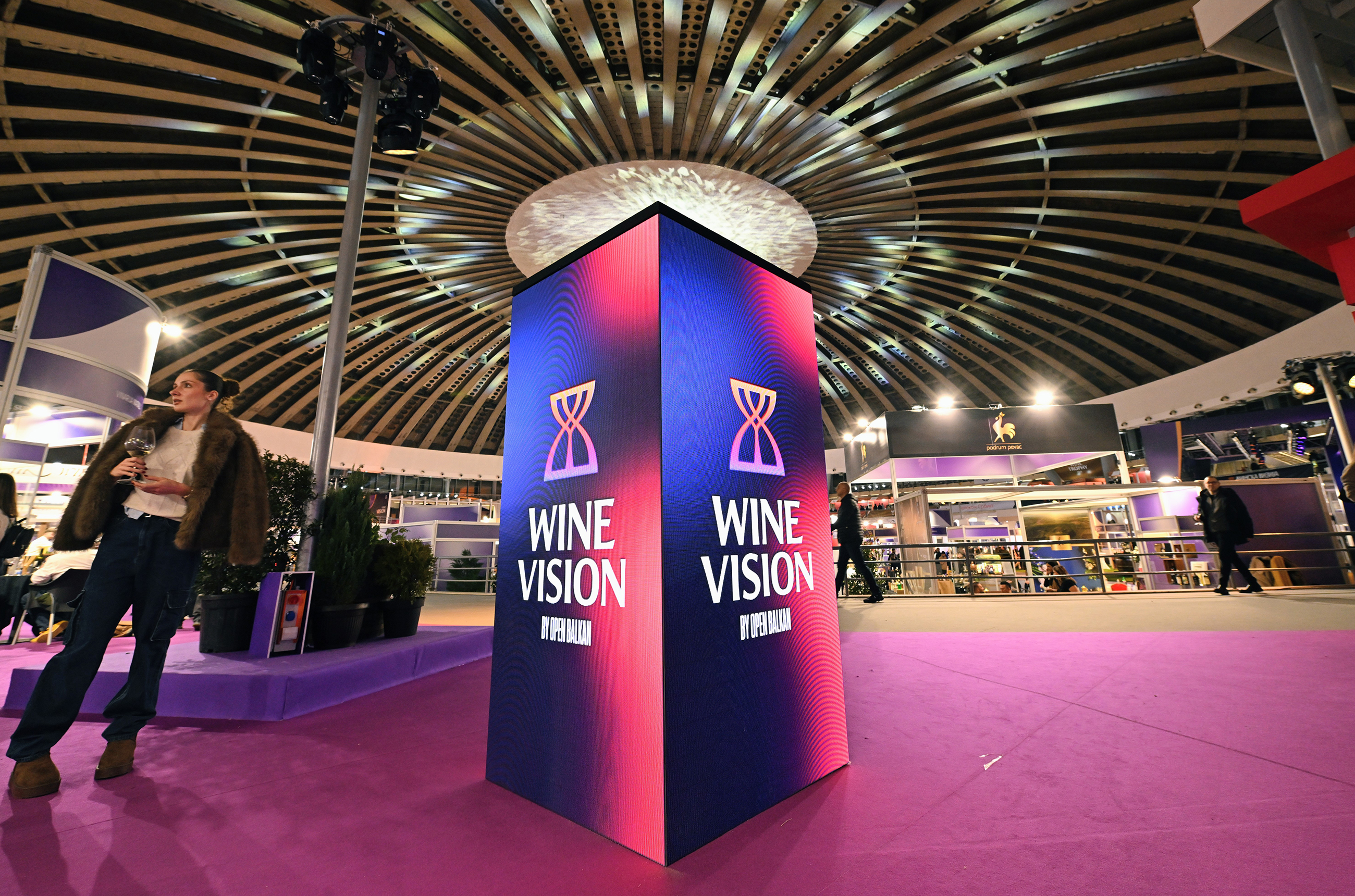 Purple and pink plinth in large room which says 'Wine Vision by Open Balkan' 