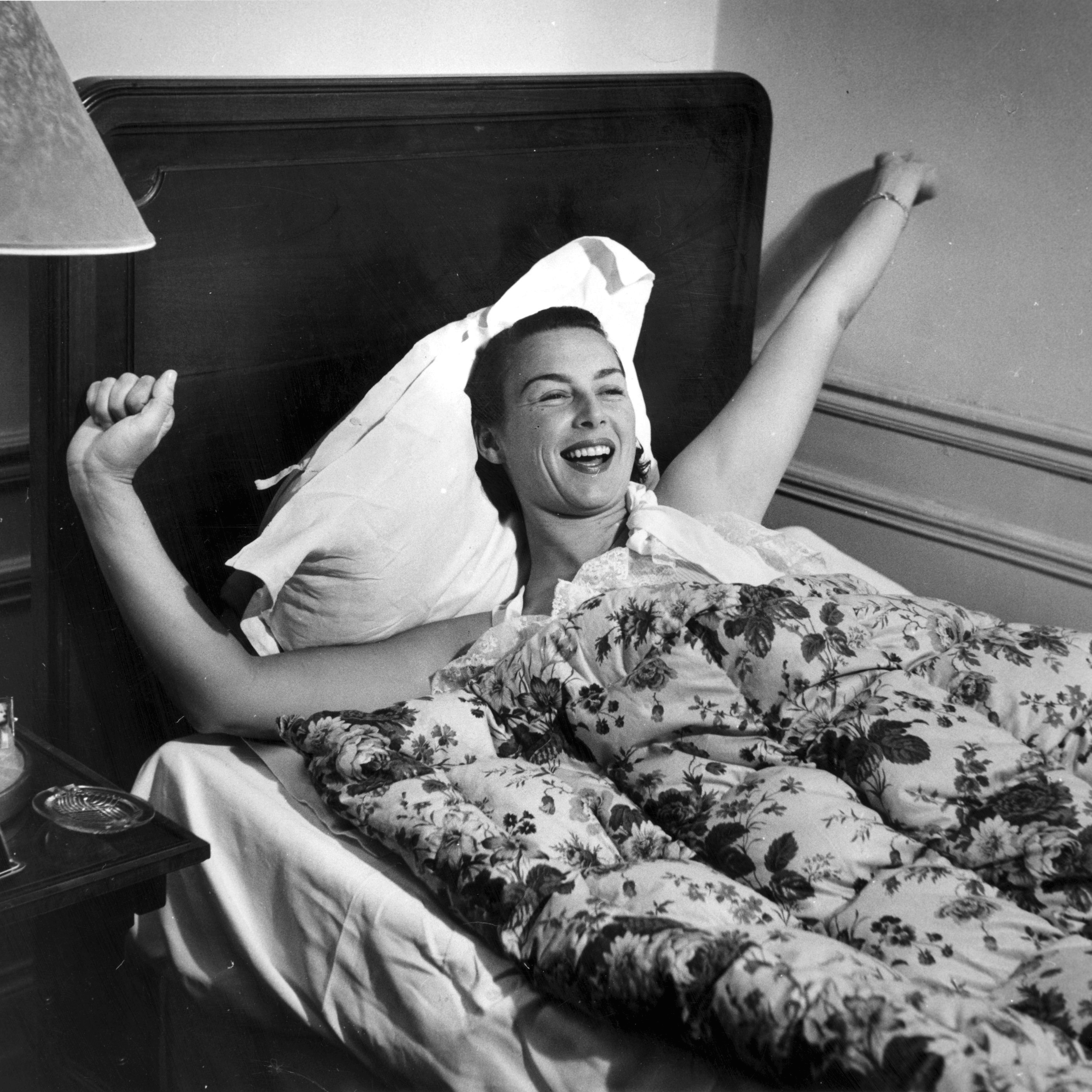 Vintage image of woman waking up in bed