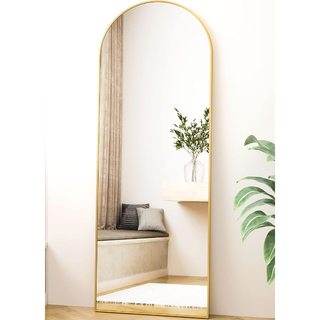 full length arched gold mirror in a living room