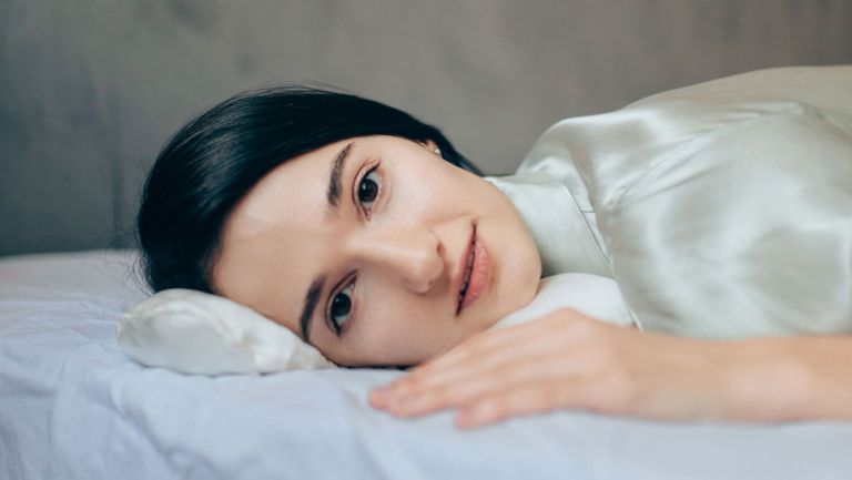 Woman Laying Down Wearing Silk Pajamas