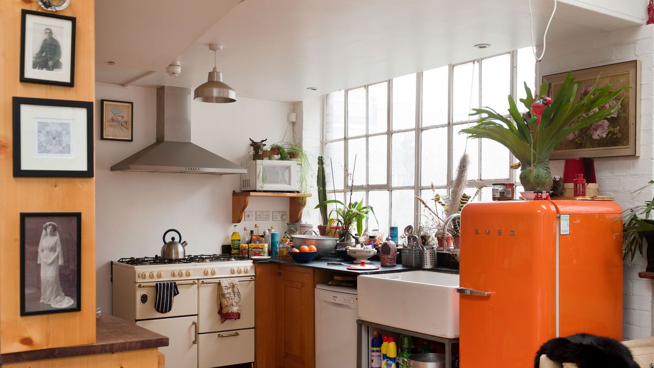 kitchen with orange fridge and a microwave