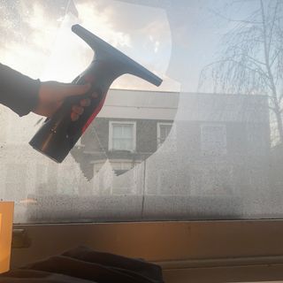 Image of condensation on windows being cleared by a window vacuum