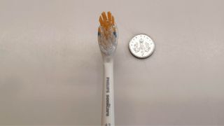 Philips Sonicare Diamond Clean Prestige 9900 toothbrush head compared in size to a 5p piece