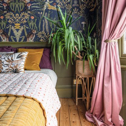 Bedroom with wallpaper accent wall and wall panelling, jewel toned bedding and houseplant