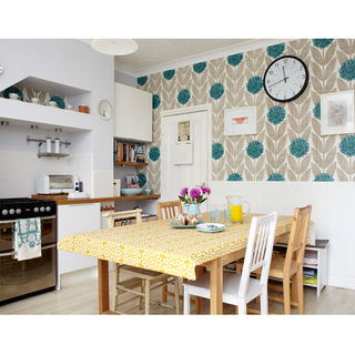 kitchen room with wall clock on wall and dining table with chairs