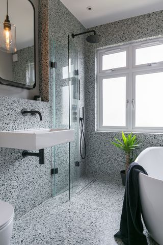 a wet room with a folding shower screen