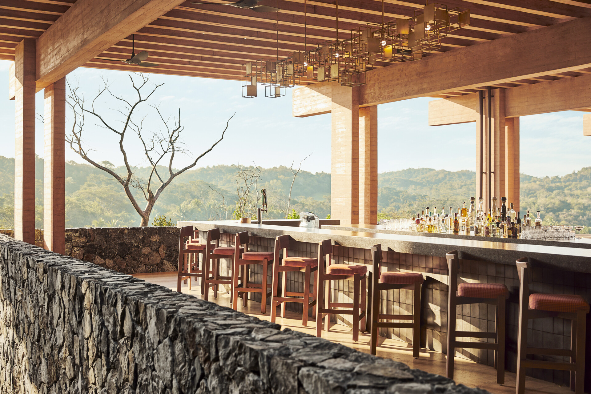 Four Seasons Tamarindo's restaurant Coyul during the day. Featuring expansive space, tan, tonal interiors and stones accents in an indoor-outdoor setting.