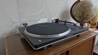 Audio-Technica AT-LP70XBT turntable, with the dust cover open, on a wooden table