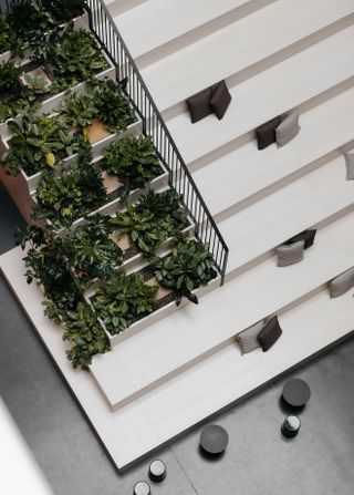 View from above of the atrium with steps, seating area and green plants at Oper46, Frankfurt