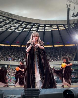 Taylor Swift wears an Alberta Ferretti cape over her Eras Tour Alberta Ferretti dress while performing in Europe