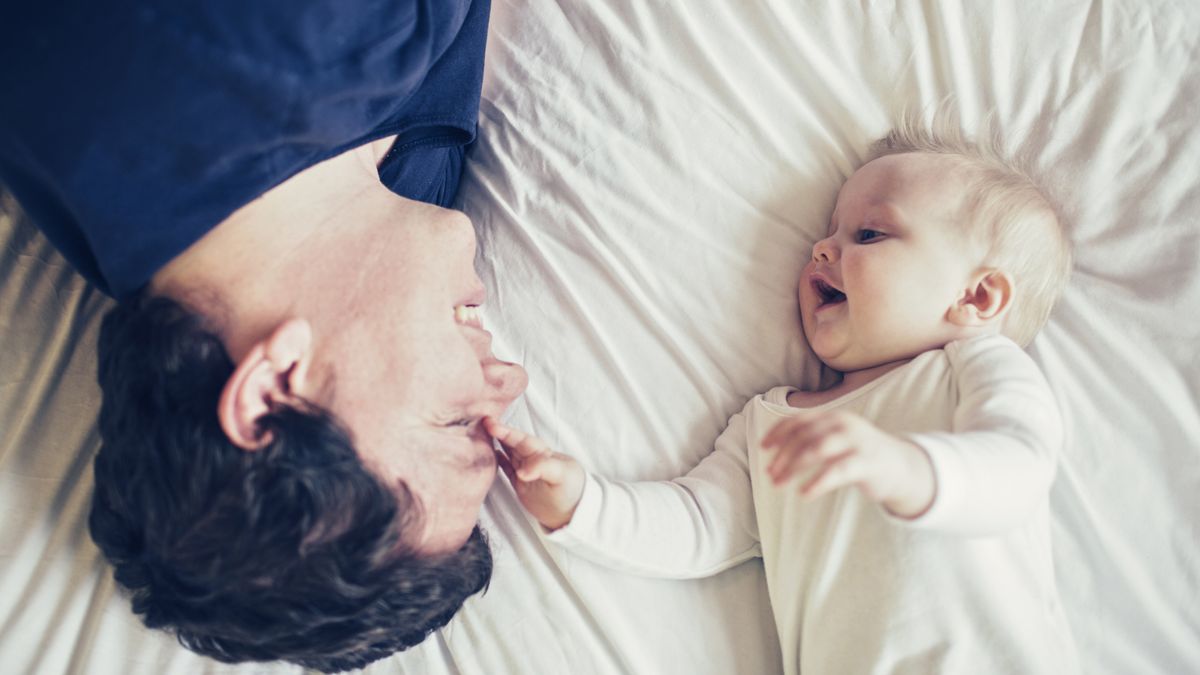 Mattress maker Tuft &amp; Needle launches program for sleep-deprived new parents: A father lies on a mattress next to his laughing baby