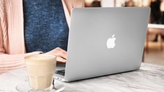 Woman using Apple Macbook Air at table