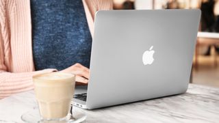 Femme utilisant un Apple Macbook Air sur une table