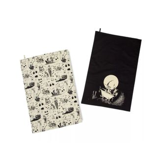 Two Halloween tea towels, one black and one white with a black pattern