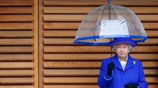 The Queen wearing a blue dress and holding a blue and clear umbrella as she visits the new National Tennis Centre, Roehampton on March 29, 2007 in London, England. The Queen is Patron of the Lawn Tennis Association and officially opened the new centre after being given a tour of the facilities.