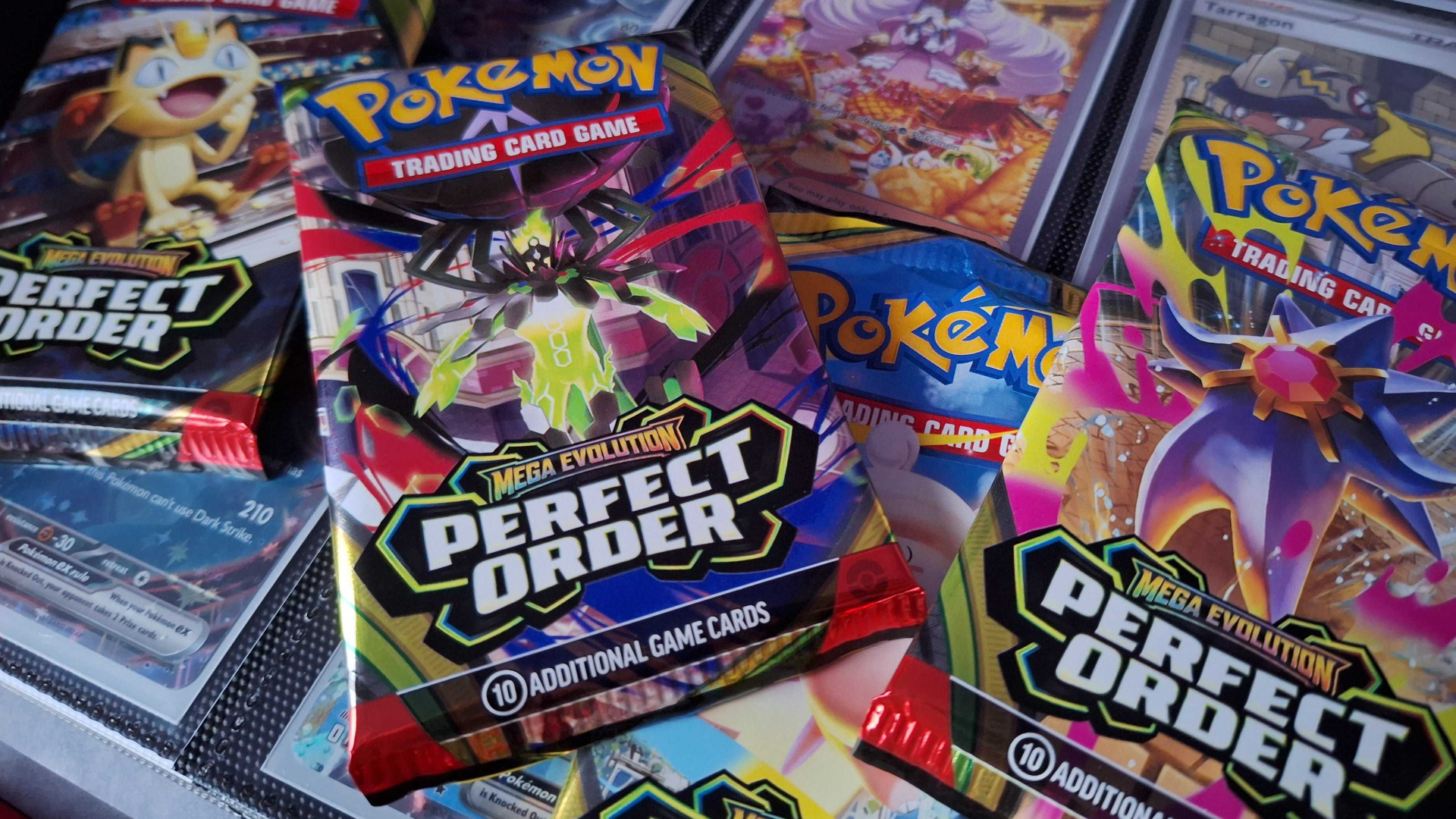 An array of Perfect Order booster packs on top of cards in a binder