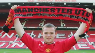 MANCHESTER, ENGLAND - AUGUST 31: Wayne Rooney poses for photographs with a Manchester United shirt and scarf after signing for Manchester United on August 31, 2004 at Old Trafford in Manchester, England. (Photo by John Peters/Manchester United via Getty Images)