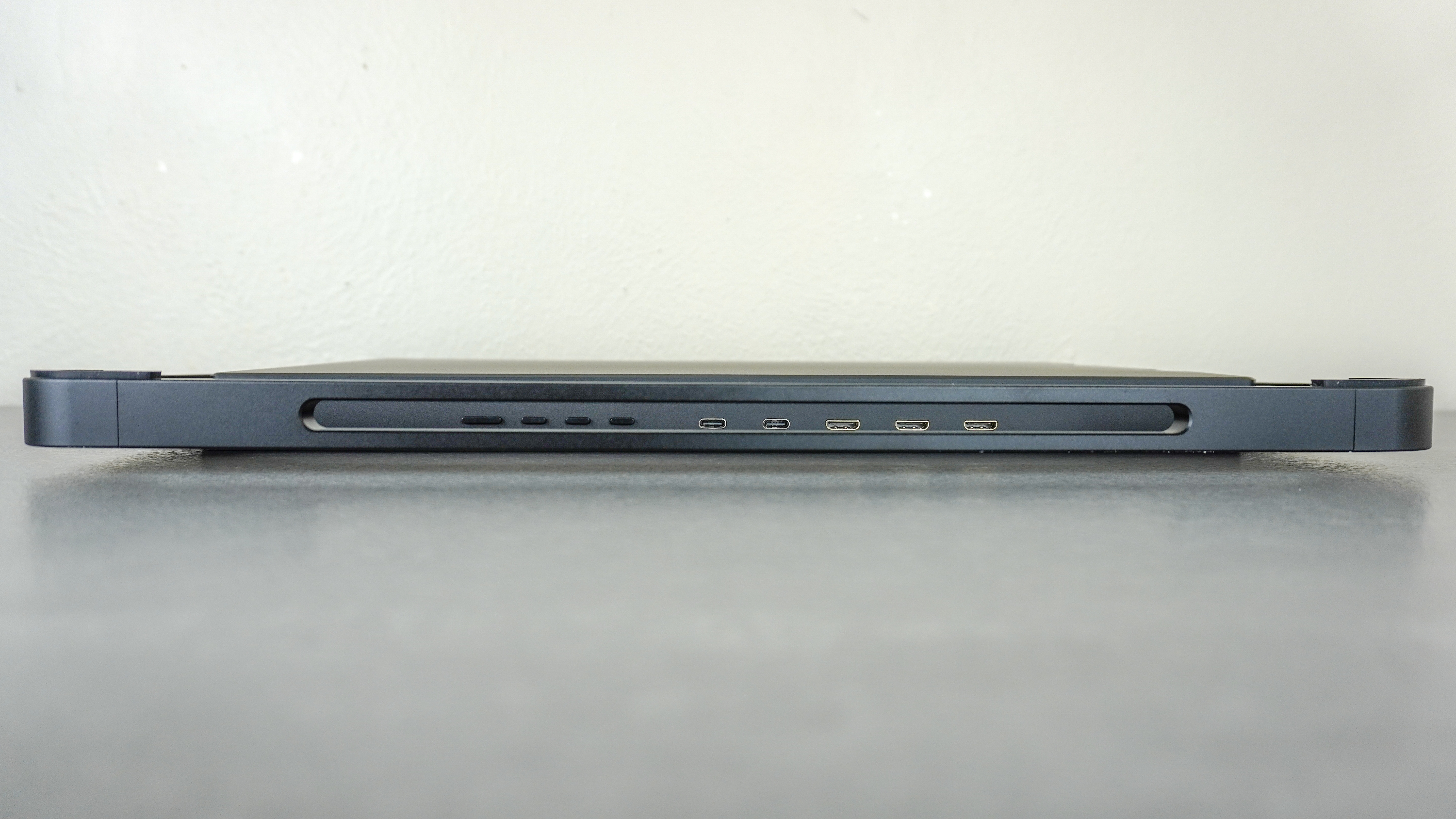 The Aura Triple Aero 15.6 Pro Max laying on its side on a desk showing off its ports and buttons