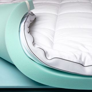 Viscosoft Serene Hybrid Mattress Topper on corner of the bed, curled up