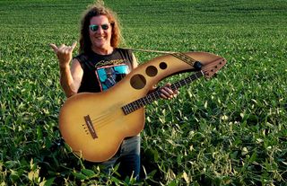Troy Johnson holds his acoustic bass in an open field