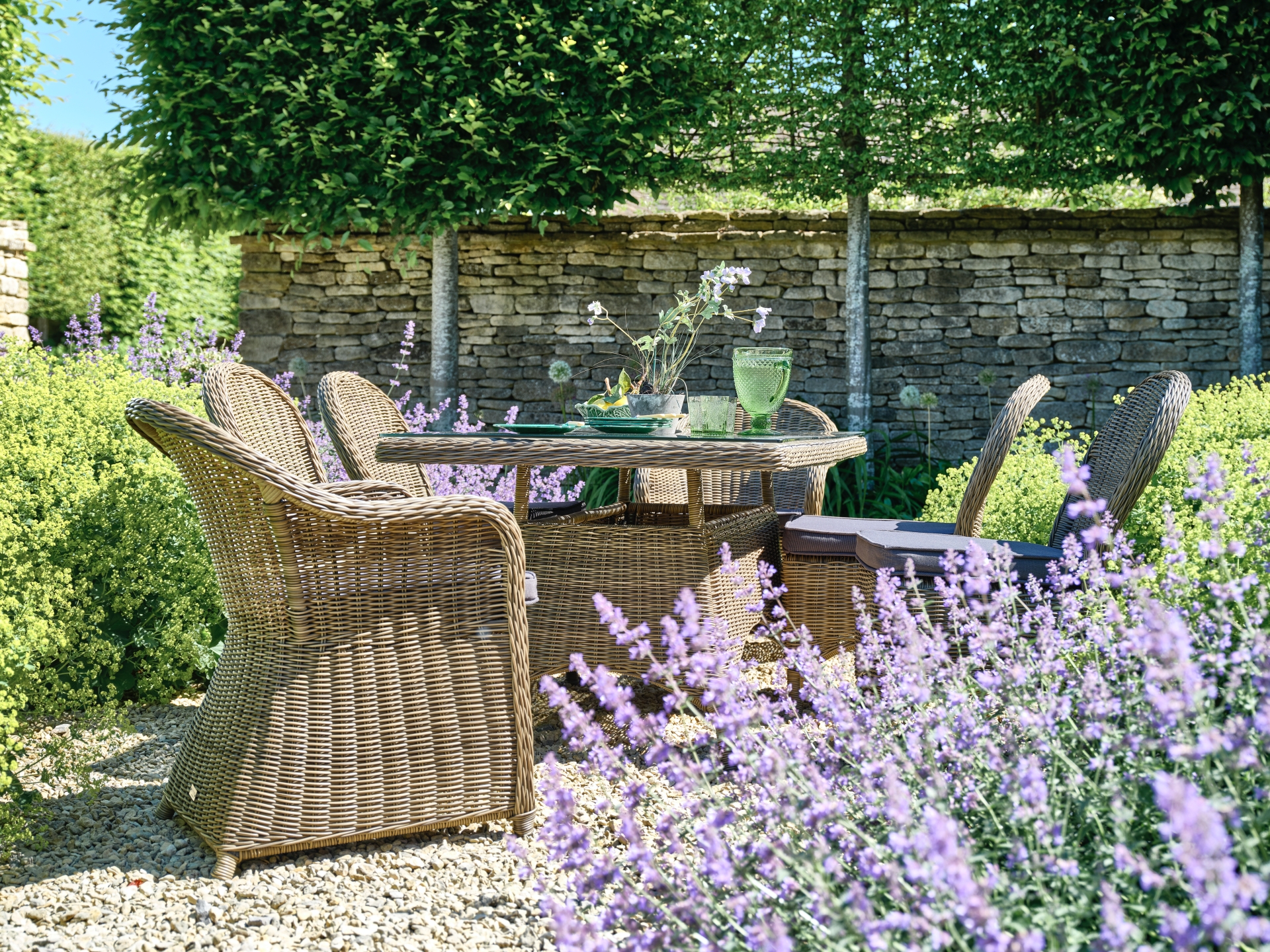 rattan garden furniture in courtyard garden with lavender
