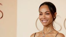 zoe saldana at the oscars on a beige background