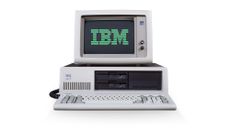 A front view of the IBM Personal Computer on a plain white background with the IBM logo on the screen in green