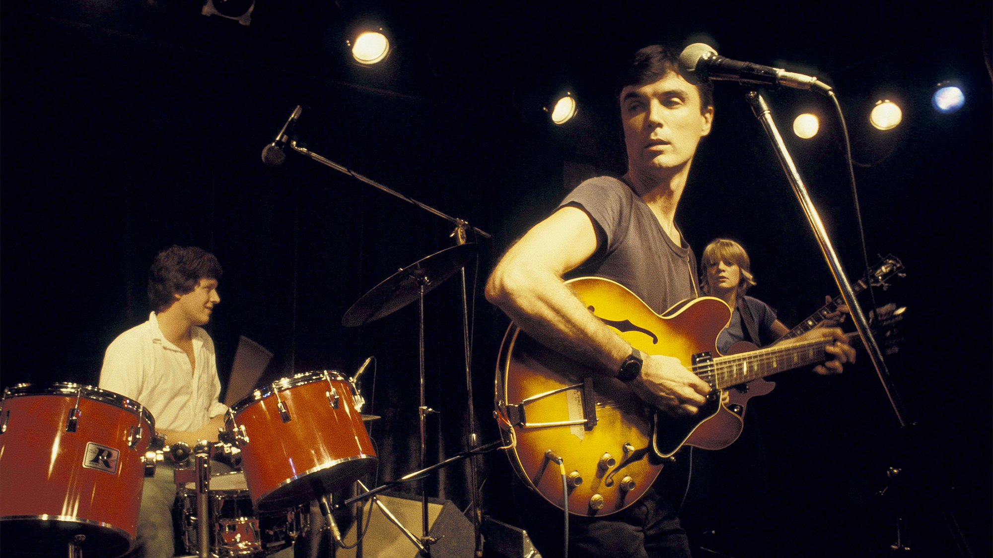 Photo of TALKING HEADS and Chris FRANTZ and David BYRNE and Tina WEYMOUTH; Chris Frantz (drums), David Byrne and Tina Weymouth performing on stage circa 1977