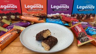 Protein Works Loaded Legends protein bar cut in half on plate with packaging behind