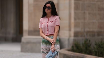  Leo Eberlin seen wearing Jimmy Fairly brown tortoise round shaped sunglasses, Leo Mathild diamond jewelry, pearl bracelets, Missoni colorful light pink zigzag print pattern pants, pink / red cropped knit top, Chanel light blue checked pattern denim bag, on August 14, 2023 in Berlin, Germany.